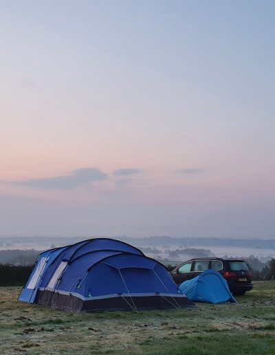 Pink blush sky in the early morning with family tent in view